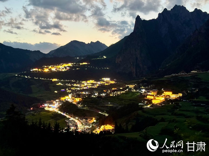远眺扎尕那夜景，群山隐入夜色，村中灯火明亮。人民网记者 焦隆摄