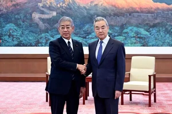 中国外交部长王毅（右）与日本前外相岩屋毅握手（28日，北京，图片来自中国外交部网站，kyodo）