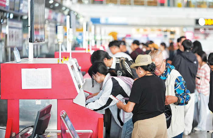 北京首都国际机场T3航站楼，旅客在自助柜台办理托运手续。
