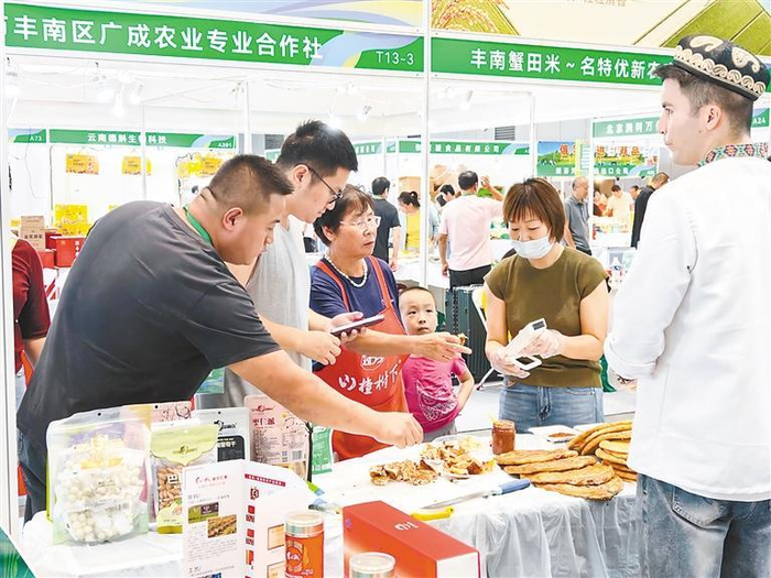     图为展台前工作人员向客商和市民介绍产品。本报记者 盛嘉敏 摄