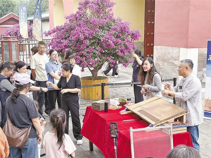     图为谷俊明（右一）在介绍制香技艺。本报记者 马颖劼 摄