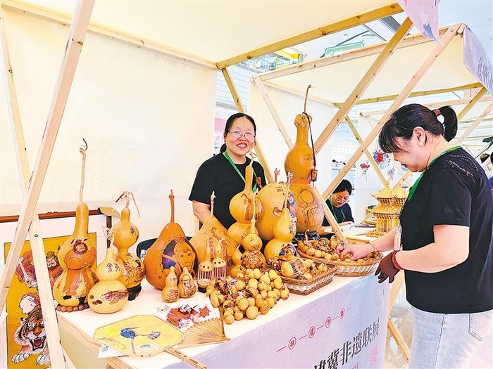     图为市民在选购心仪的非遗作品。 本报记者 张甜歌 摄