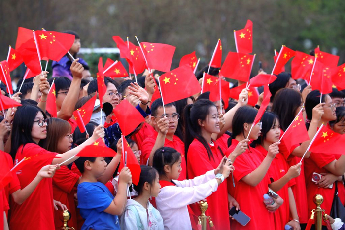 10月1日，人们在云南省昆明市东风广场参加升旗仪式后观看演出。新华社发（郑益 摄）