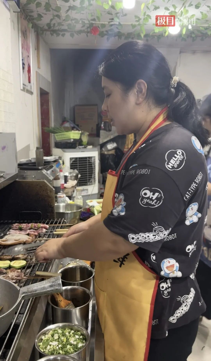 烧烤店老板娘正在忙着烤烧烤（极目新闻记者 邓波 摄）