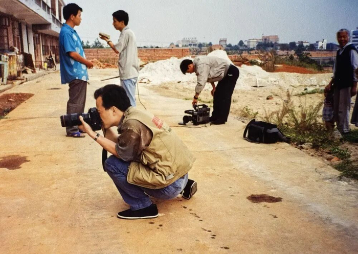 1996年，刘卫兵（前）在江西泰和县采访拍摄铁路沿线的乌鸡产业。