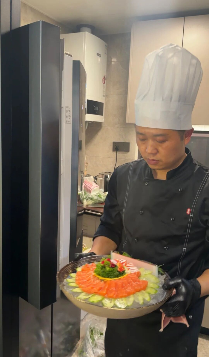 匡先生端着菜品上桌。图/受访者提供