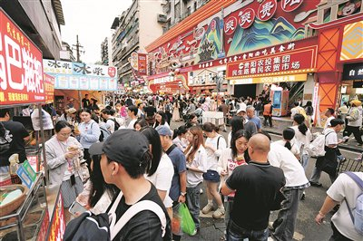 10月2日，民生路上游人如织，不少市民游客排着长队，等候购买心仪的美食。     贵阳日报融媒体记者 徐其飞 摄