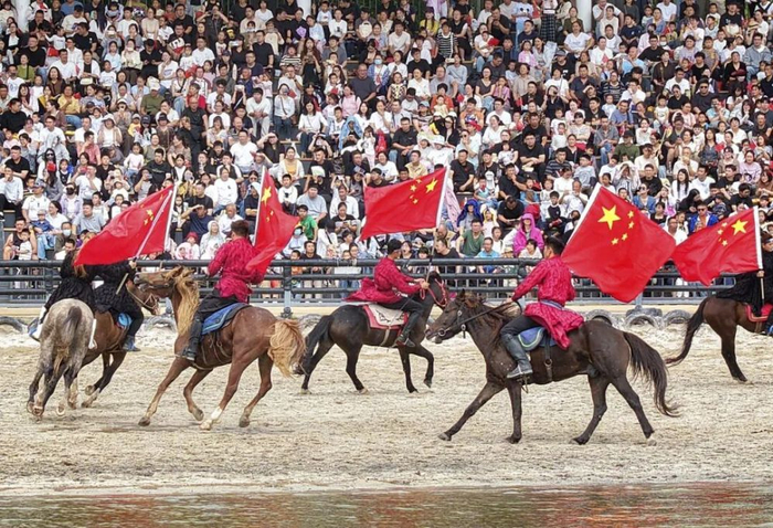 10月1日，游客在江苏南通森迪旅游度假区观看马术编队表演（无人机照片）。新华社发（许丛军摄）