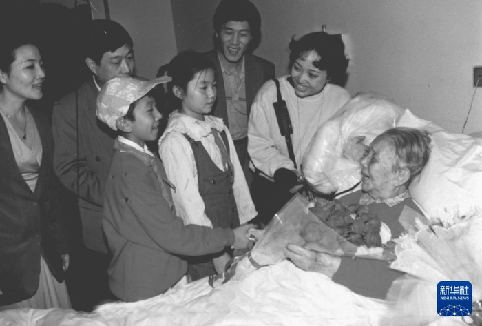   1995年10月10日，冰心（右一）在北京医院接受首都少年儿童代表的祝福，她寄语孩子们要好好学习，多读书，读好书。