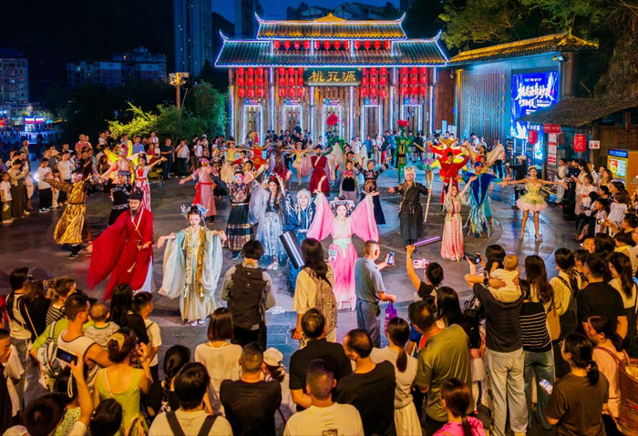 图为游客在桃花源景区体验“酉阳奇妙夜”活动。