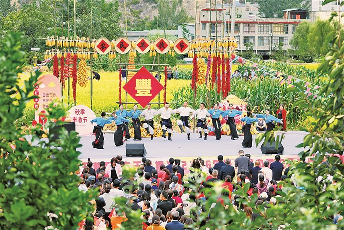 在文县城关镇西元村，人们在农民丰收节的舞台上载歌载舞。