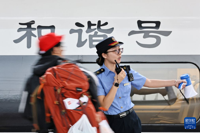   10月1日，在浙江嘉兴南站，工作人员在站台引导旅客有序乘车。新华社发（金鹏 摄）