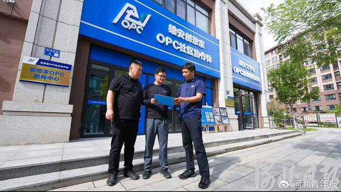 10月4日，雄安创想家OPC社区协作体工作人员为入驻者（中）介绍一站式创业服务内容