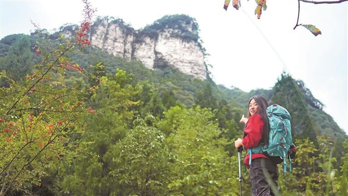 来自四川乐山的游客袁妮带着装备进山徒步。 本报记者 杨柳 摄
