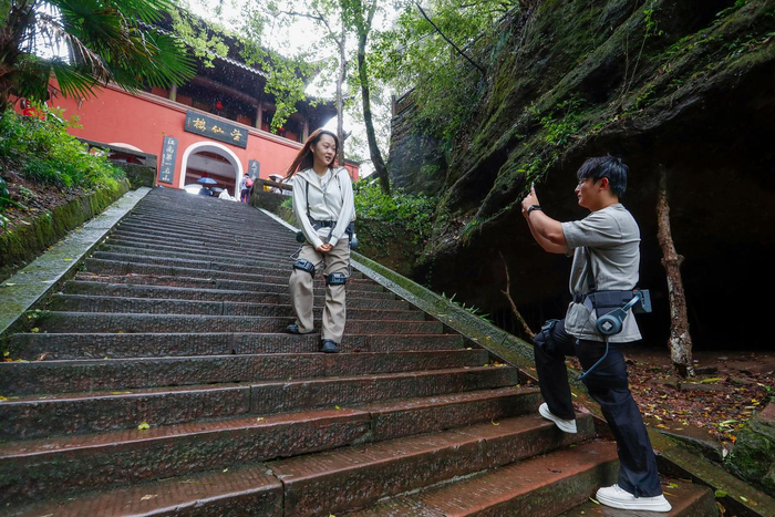 10月2日，游客穿戴外骨骼机器人在齐云山景区登山。新华社发（施亚磊摄）
