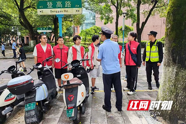 城管队员和志愿者讲解路口维护事宜。