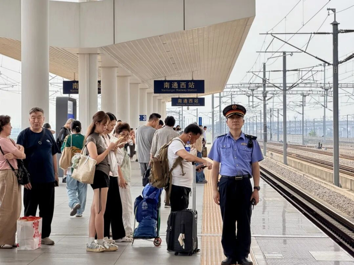 南通西站客运值班员组织旅客候车，目迎列车进站。宋潇璇摄