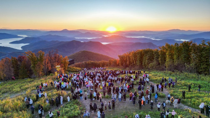 10月2日，游客在吉林省中旅松花湖度假区山顶观看日出。新华社记者 颜麟蕴 摄
