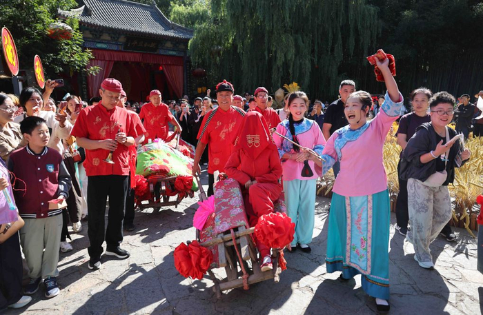 10月5日，在山东省临沂市沂南县竹泉村，游客在观看《沂蒙婚嫁》表演。新华社发（王彦冰 摄）