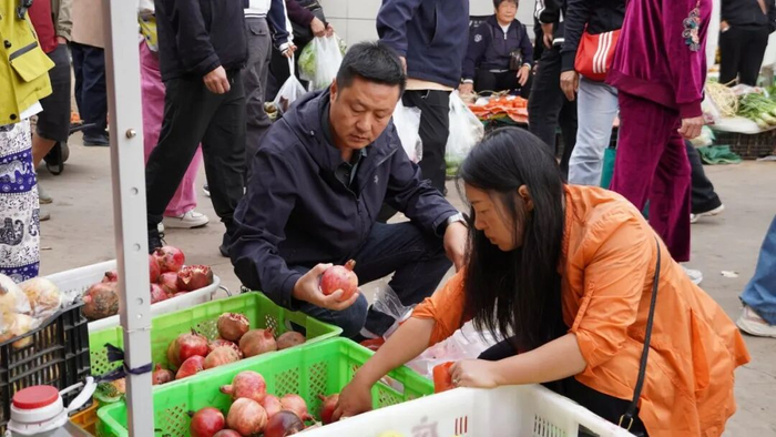 游客陈少雄在挑选石榴