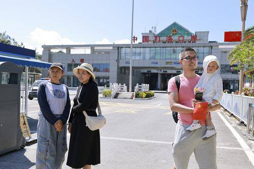 国庆期间，游客在国家一类开放口岸打洛口岸前拍照留影，定格边境之旅的独特瞬间。胡妤雅 摄