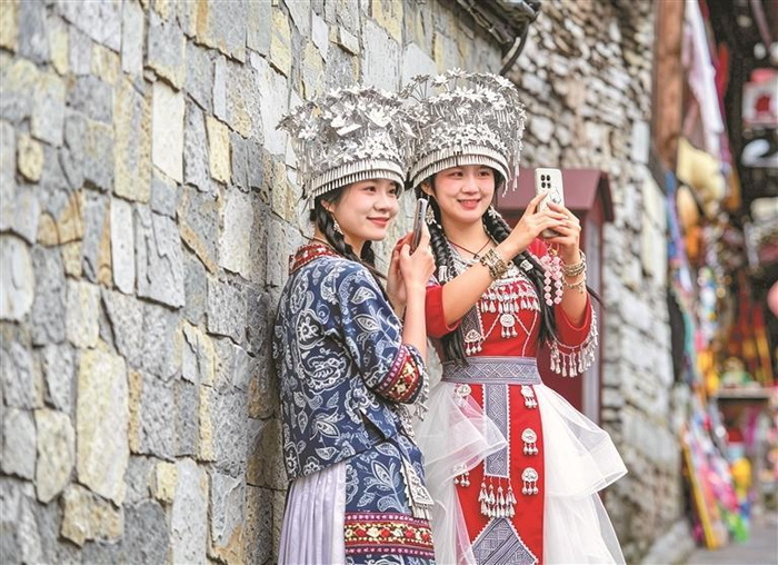 10月5日，贵阳市青岩古镇，身着民族服饰的游客漫步古巷旅拍，在斑驳石墙间定格独具韵味的民族风影像。 本报记者 陈慧 摄