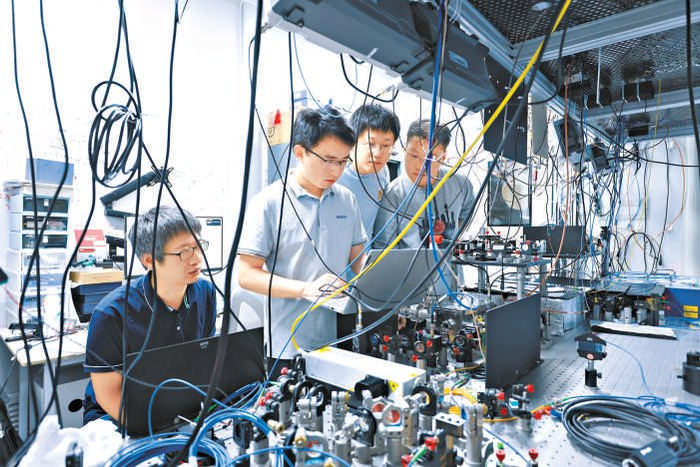 清华大学物理系副教授丁世谦（左二）与团队成员做实验。 受访者 供图
