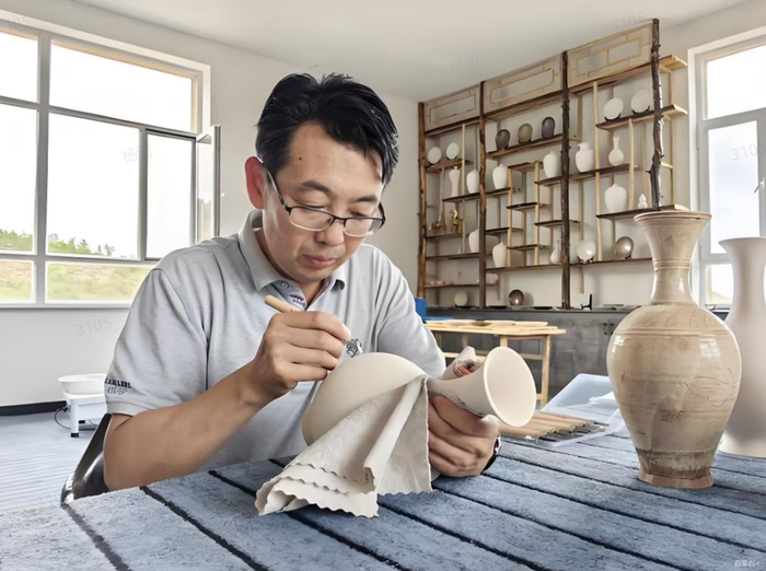 　　▲李海刚细致修整瓷胎素面。一遍遍手工打磨修饰，保留手工陶瓷独有的肌理，是辽瓷创作当中十分关键的工序。摄影：袁向南