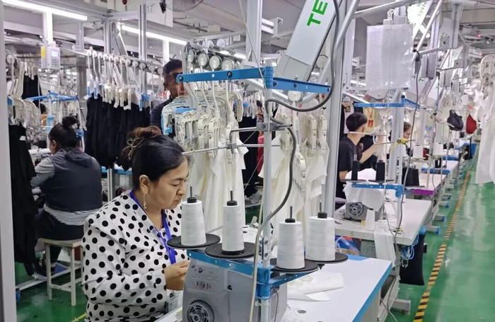 ▲经纶服饰有限公司工人图拉妮萨在工作。王珍摄