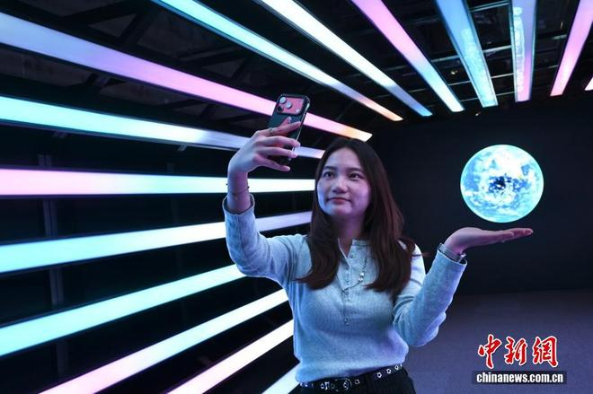  中新网记者 李志华 摄 图为一名女士与地球的影像自拍。