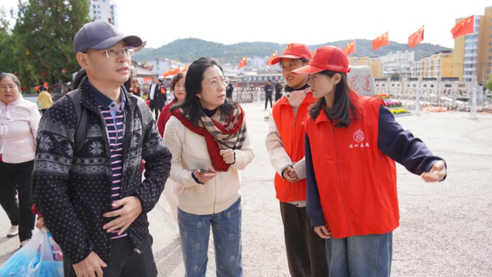▲党员志愿者耐心解答游客问题