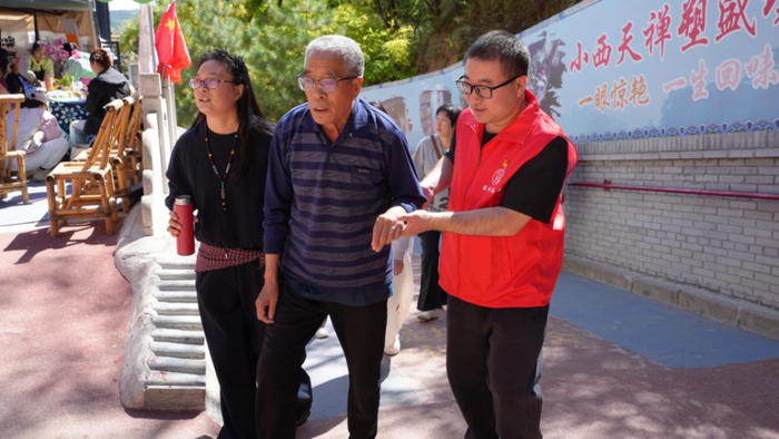 ▲党员志愿者帮助高龄游客