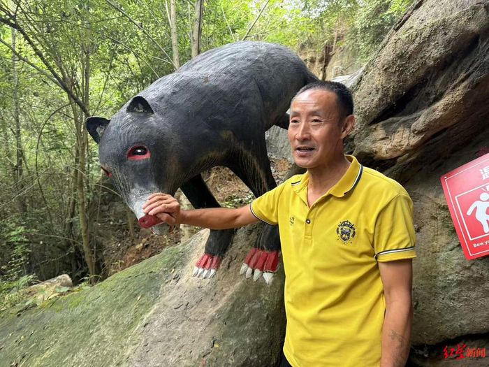贺昌林向游客们讲解黑熊雕塑的寓意