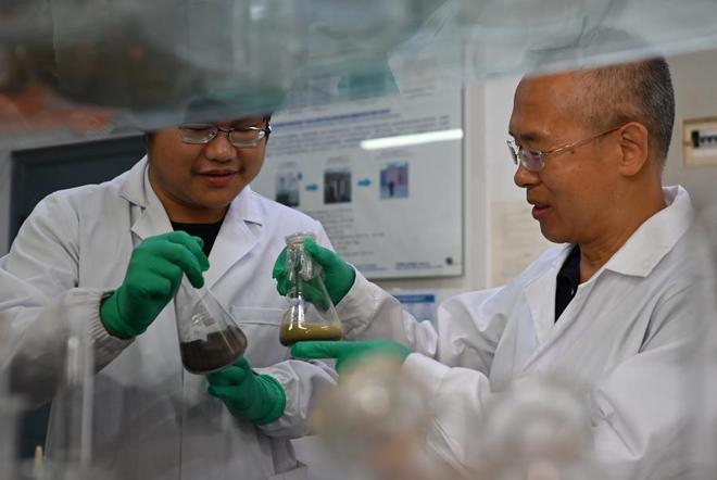 张旭教授（右）领衔参展项目“含金属固废资源化和无害化生物反应器技术”。徐瑞哲 摄