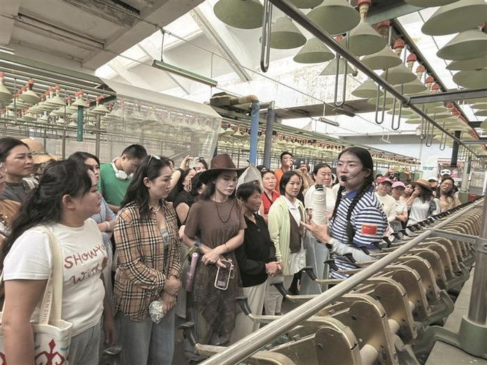     9月14日，游客在八师石河子戈壁印象文化和旅游园内聆听导游介绍兵团工业早期发展史。    兵团日报常驻记者  李秀  摄