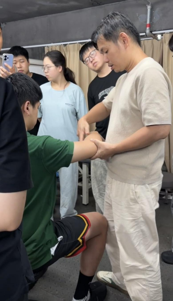 陈泽尧向学生示范中医手法。