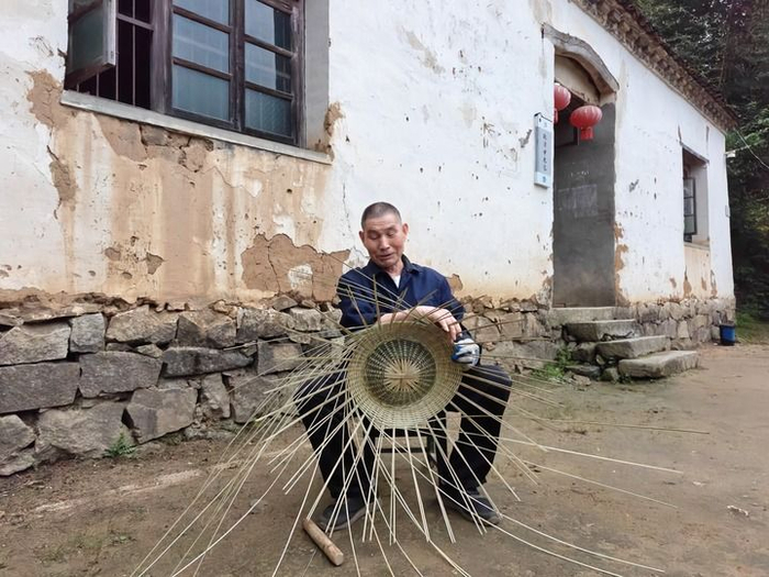金寨县花石乡大湾村村民陈泽申在编织竹篮。新华社记者 陈诺 摄