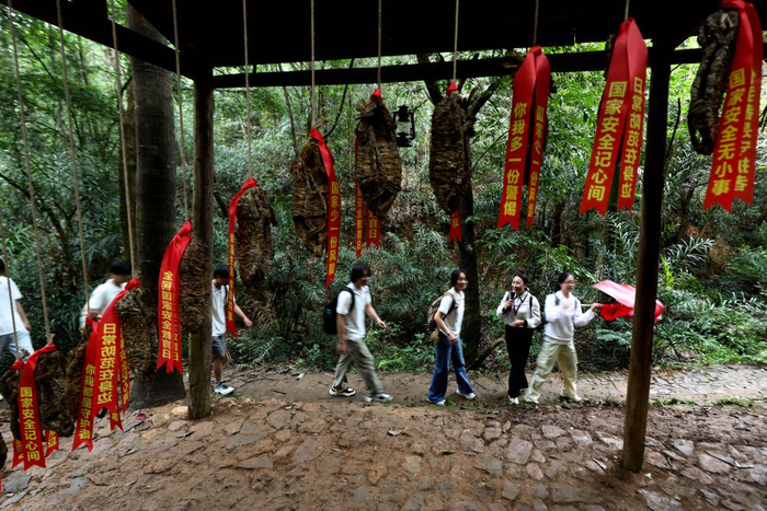  2026年7月30日，胡石招（右二）带领中国石油大学（北京）“薪火传志”社会实践团师生行走在位于江西于都祁禄山镇的红军长征小道。新华社记者 刘金海 摄