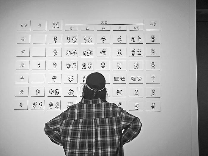 　　上图为“土方入侵”涂朱卜骨；下图为“了不起的汉字”展览现场
