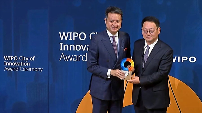 上海市政府副秘书长周亚明（右）从世界知识产权组织（WIPO）总干事邓鸿森手中接过创新城市奖杯。