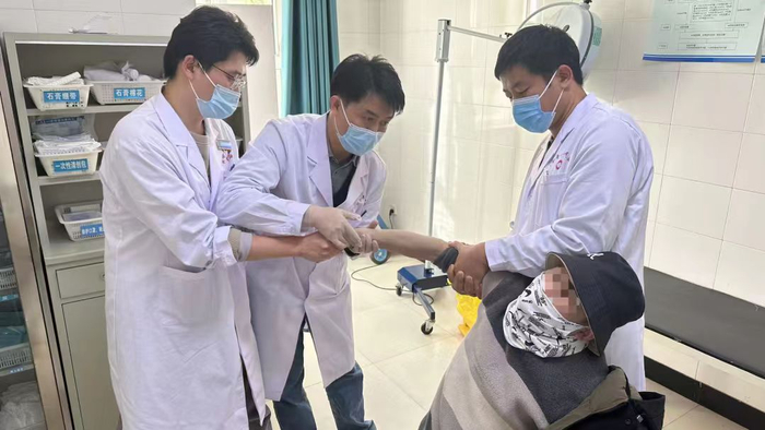 殷铭正在为骨折的阿合奇当地居民进行手法复位。无锡市中医医院供图