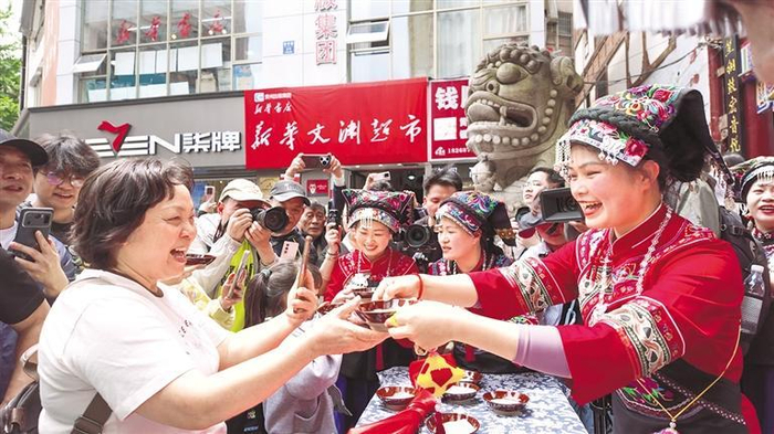   都匀市石板街，十五分钟生活圈里的民俗文化活动吸引居民游客喝拦门酒、跳竹竿舞。           通讯员 邹元红 摄