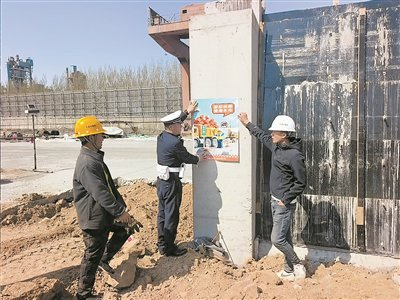 　　交警在工人休息点张贴宣传海报。