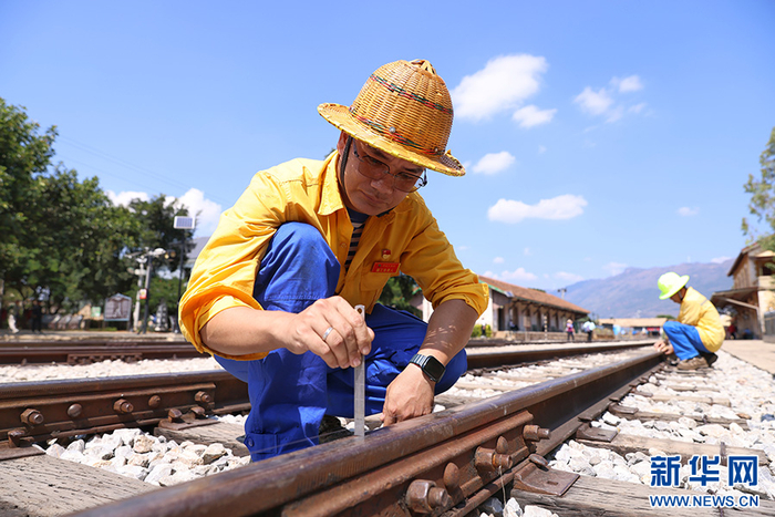 碧色寨线路工区工长白青正在测量线路高低尺寸（10月14日摄）。新华网发（周靖博 摄）