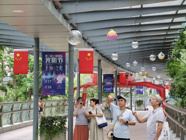 莲花路地铁站人行连廊上，在家长陪伴下，孤独症孩子打卡自己的创作。 陈玺撼摄