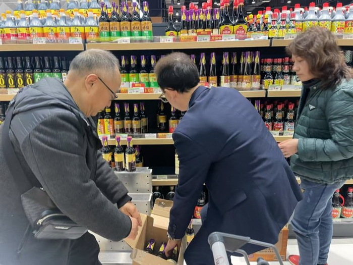 黄清林（左一）如今仍然常到一线调研市场情况