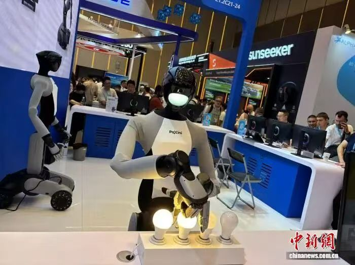 一款人形机器人正在现场演示拧灯泡。中新社 记者 孙秋霞 摄