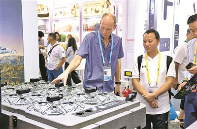 图为10月15日，参观者在第140届广交会上咨询了解飞行表演无人机产品。