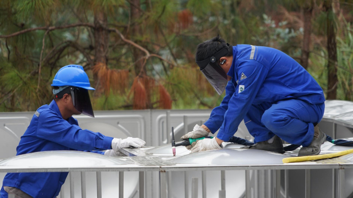 施工人员焊接蓄水池不锈钢板材