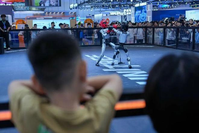 人们在2026世界机器人大会上观看人形机器人拳击演示。图源：新华社